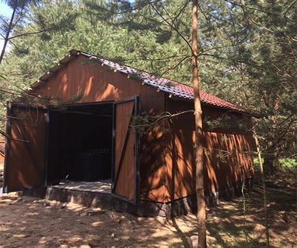 Prefabrykowany garaż drewniany 6x4 m. Widok drewnianej konstrukcji z dwuskrzydłowymi drzwiami.