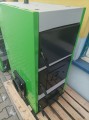 Kocioł CO na paliwo stałe KGP Grizzly II 25 kW. Widok boczny zielonego kotła z czarną komorą spalania.