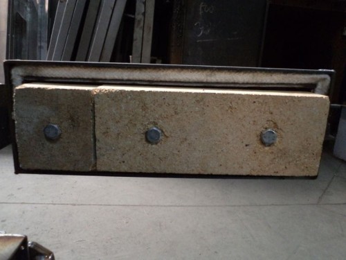 Cegła do drzwiczek (Logica 40-48, 50-58) do kotła na paliwa stałe. Trzy cegły szamotowe z widocznymi śrubami.